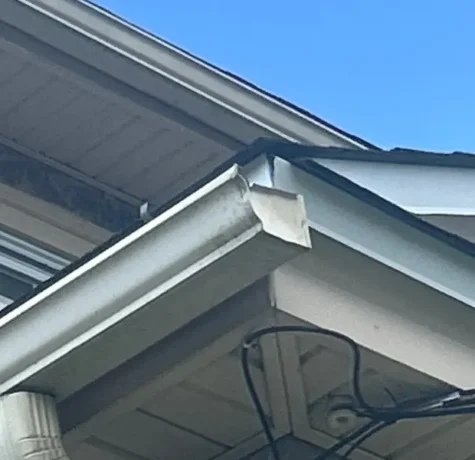White aluminum gutter and downspout corner on a Herts job