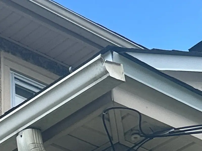 White aluminum gutter and downspout corner on a Herts job