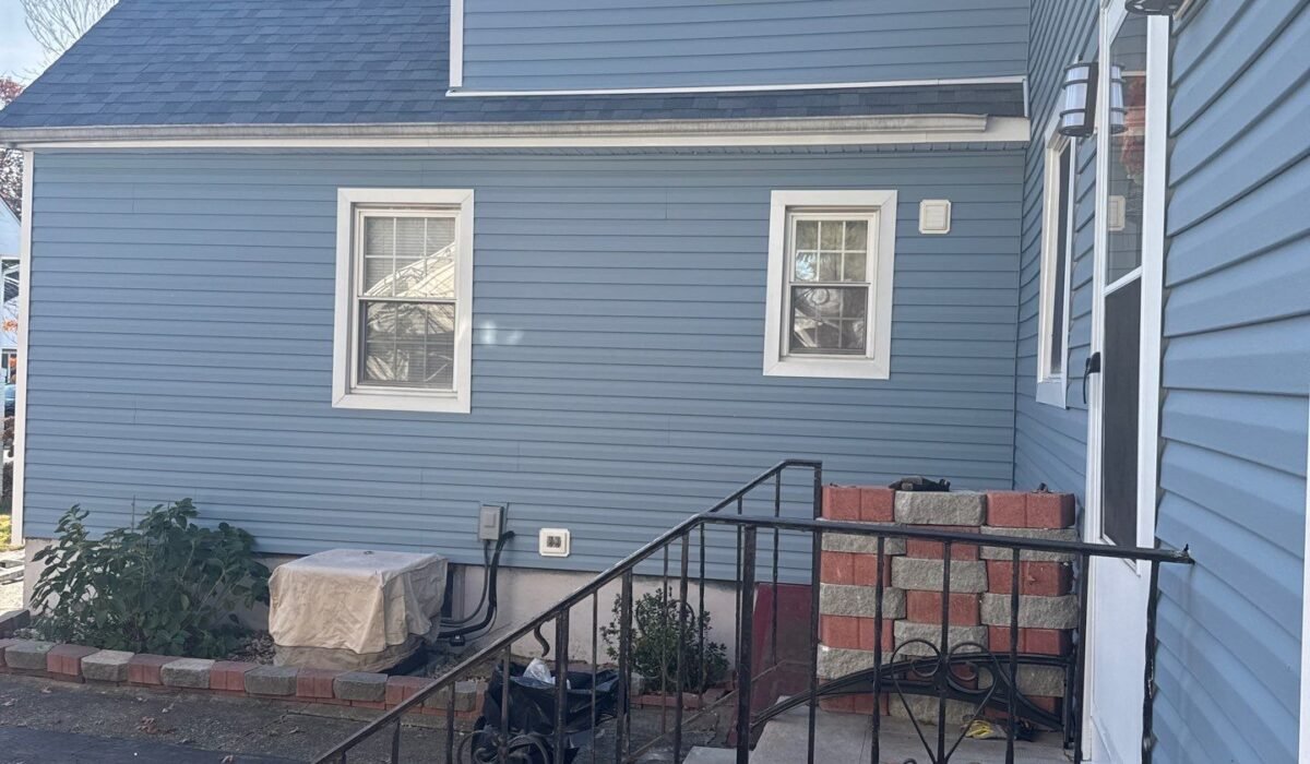 After: new blue Dutch lap vinyl siding and white trim on a Cape-style home with a full dormer in Garwood NJ