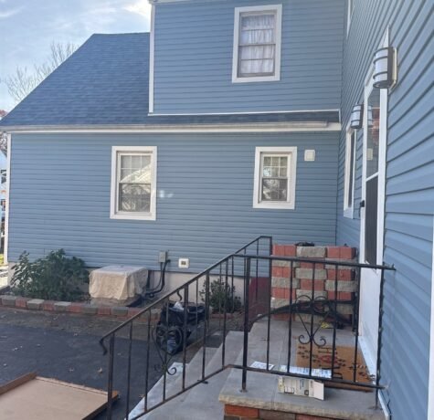 After: new blue Dutch lap vinyl siding and white trim on a Cape-style home with a full dormer in Garwood NJ