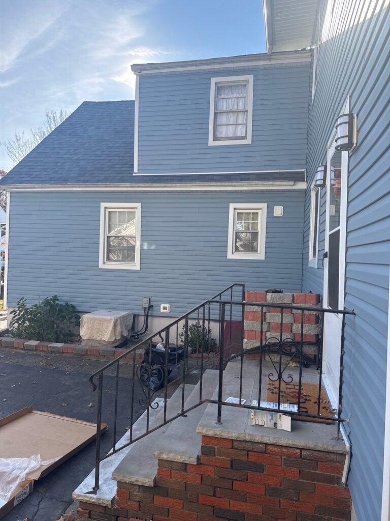After: new blue Dutch lap vinyl siding and white trim on a Cape-style home with a full dormer in Garwood NJ