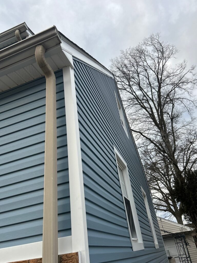 After: blue Dutch lap siding with white corner trim and soffit on a Garwood NJ home