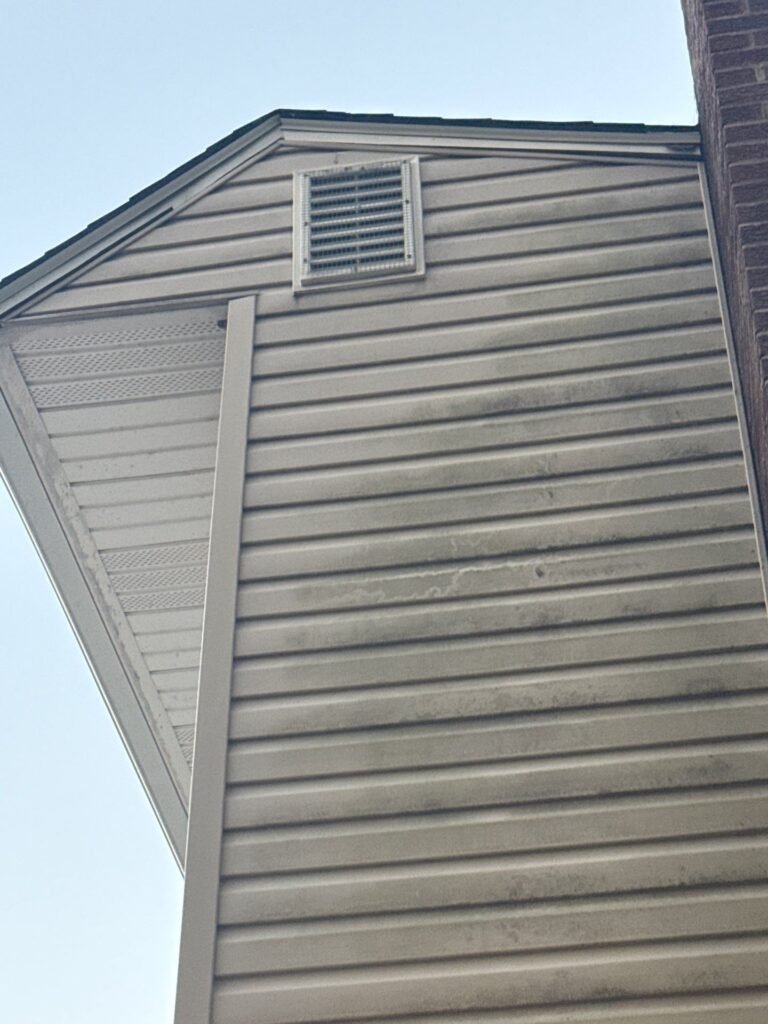 Before: mildew-streaked beige vinyl siding near the gable vent on a Garwood NJ home